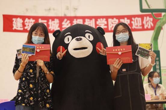 新生手握明信片与吉祥物“城哥”合影 新生手握明信片与吉祥物“城哥”合影